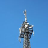 Вежа мобільного зв’язку з антенами на тлі чистого блакитного неба