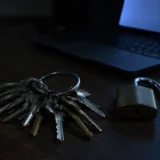 В’язка ключів і відкритий навісний замок на темному столі