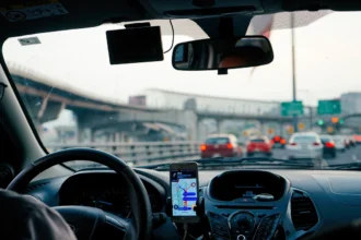 Автомобіль на шосе їде по мосту біля знака