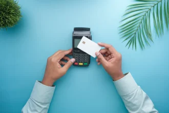 Руки прикладають безконтактну картку до термінала оплати