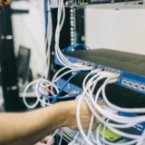 IT-спеціаліст налаштовує Ethernet-кабелі в серверній шафі