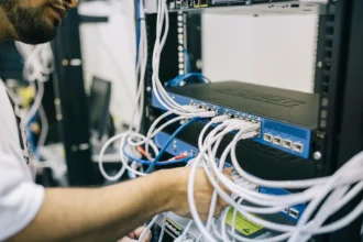 IT-спеціаліст налаштовує Ethernet-кабелі в серверній шафі