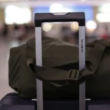 Валіза з дорожньою сумкою на перевантаженому аеропорту