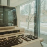 Ретро комп’ютер біля вікна зі сніжним зимовим краєвидом