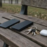Дерев'яна лавка з телефоном, футляром, ключами та білою зарядною коробкою