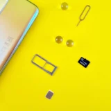 мобільний телефон із SIM-картою, лотком і карткою пам’яті на жовтому тлі