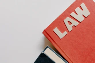 Червоний підручник права поруч із темною книгою на білому фоні