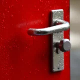 ручка дверей з краплями дощу на відчинених дверях