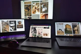 Три ноутбуки й монітор на столі з графічними дизайнами